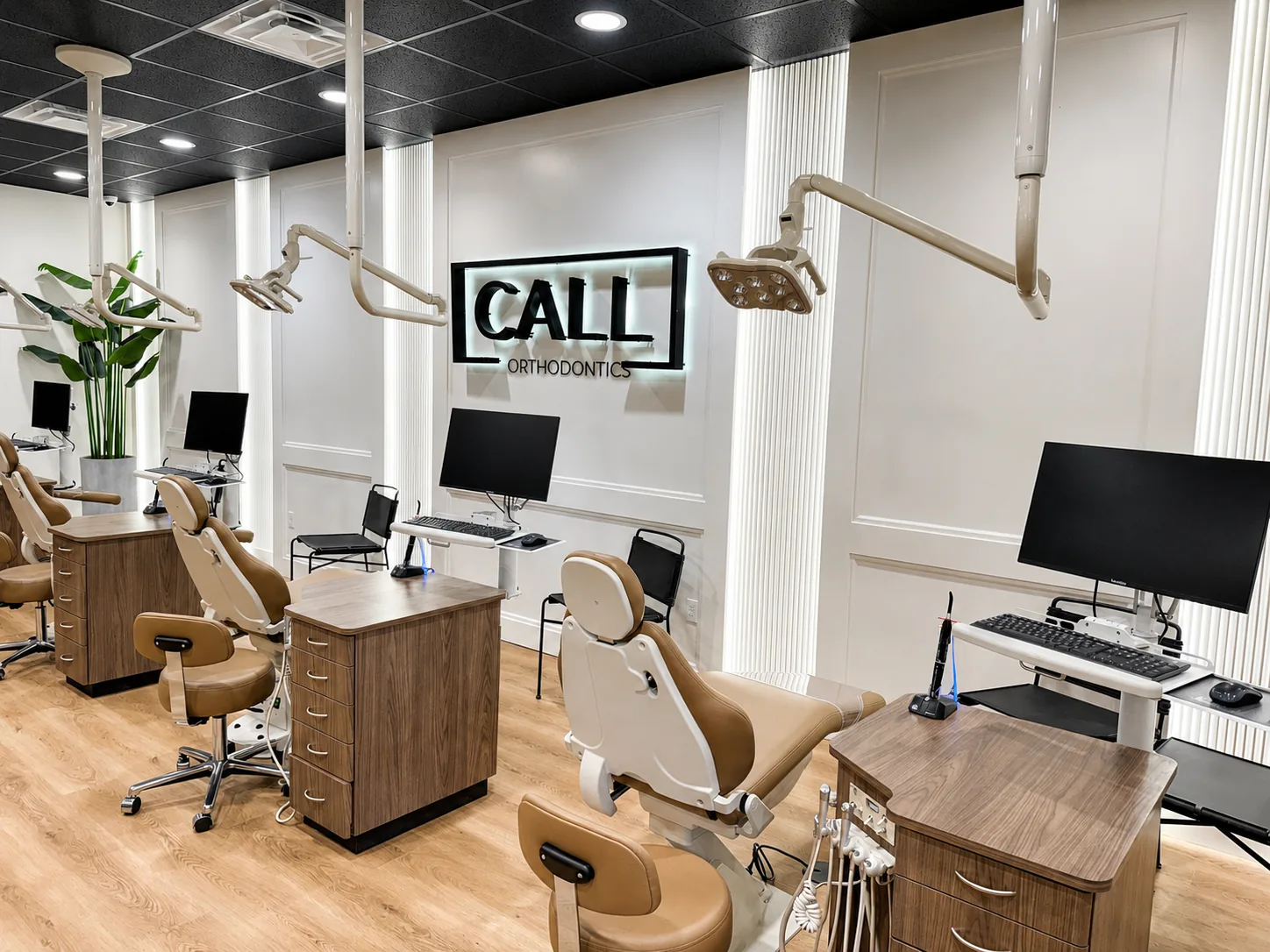 Modern orthodontic operatory with integrated workstations, displays, and clinical technology